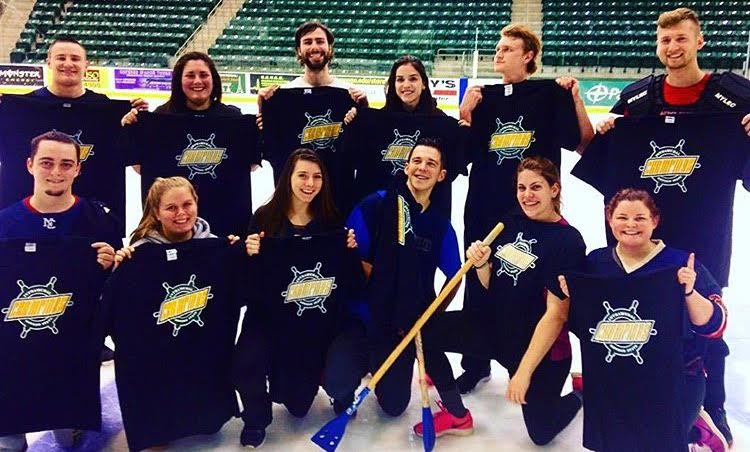 Championship broomball team poses with Lakers T-shirts