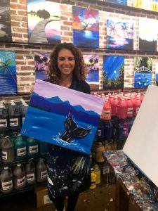 Blogger holding a painting of a whale
